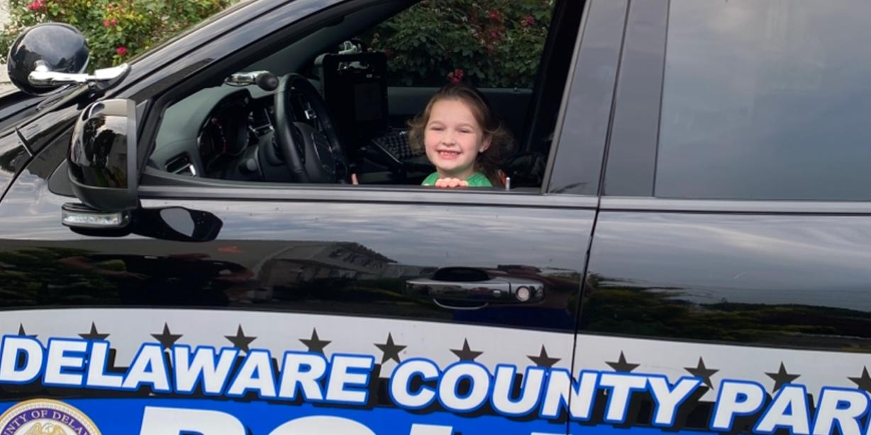 A child in a Park Police car
